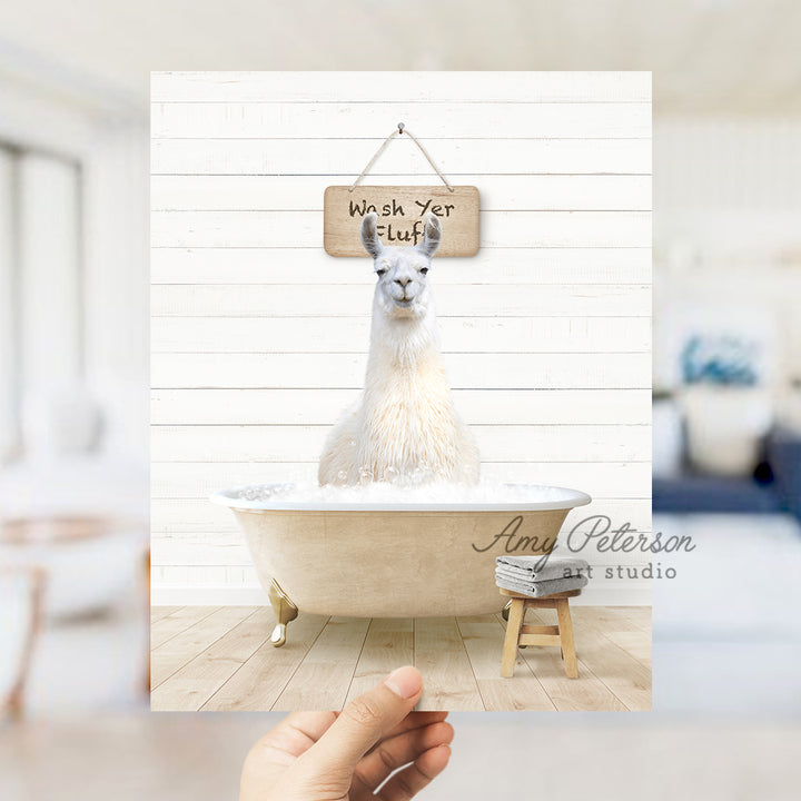 a hand holding a photo of a llama in a bathtub