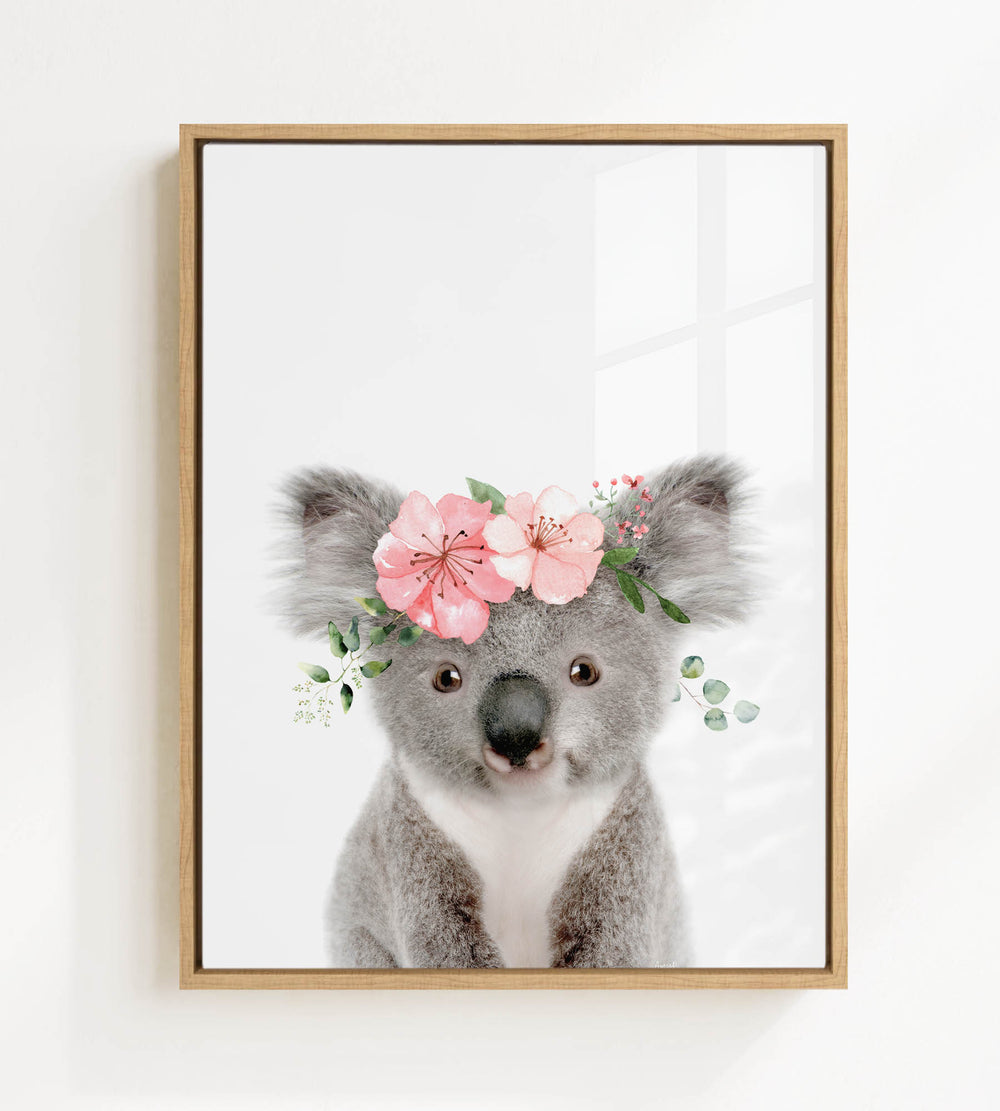 A framed image of a koala bear wearing a floral crown.