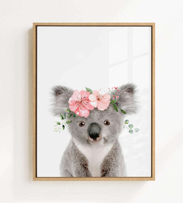 A framed image of a koala bear wearing a floral crown.
