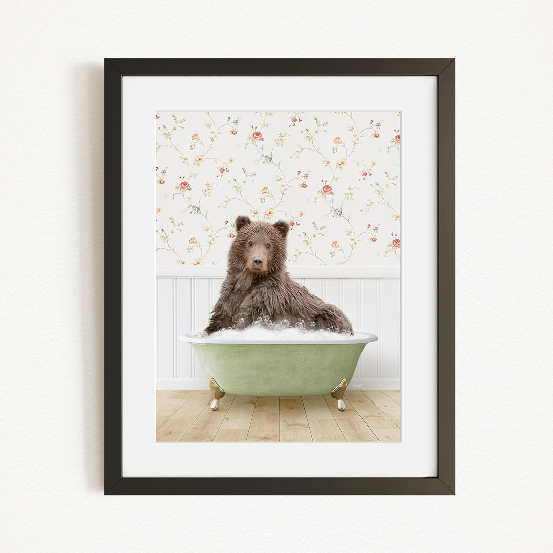 A brown bear sitting in a green bathtub filled with bubbles, with a floral wallpaper in the background.