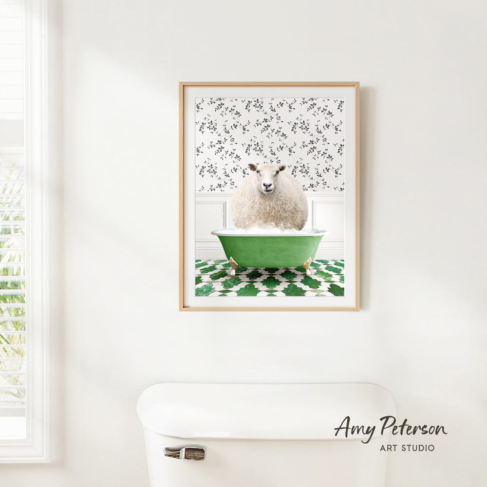 A framed image of a sheep sitting in a green bathtub, with a patterned wall behind it.