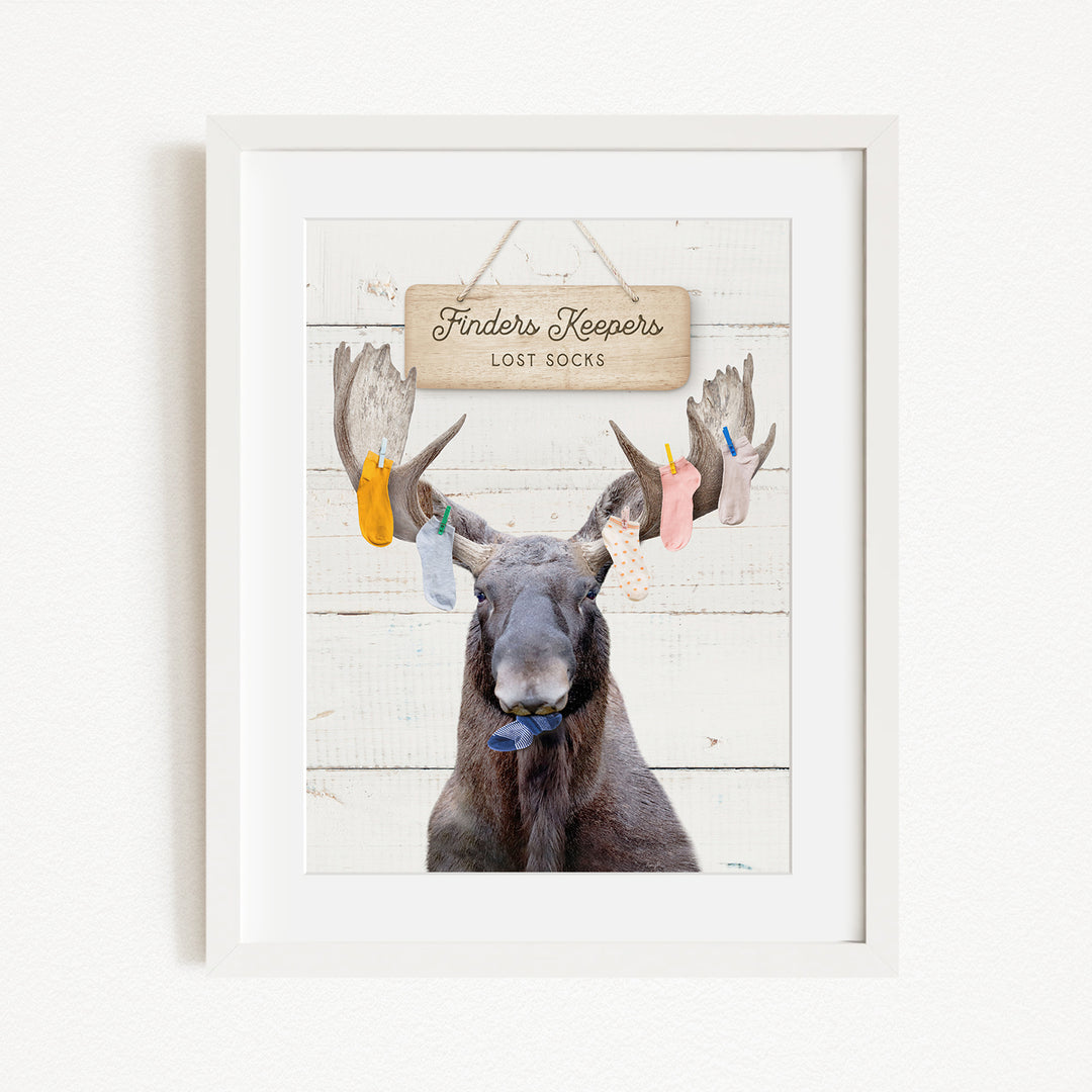 A framed image of a moose with a sign that says "Finders Keepers Lost Socks" hanging above it.
