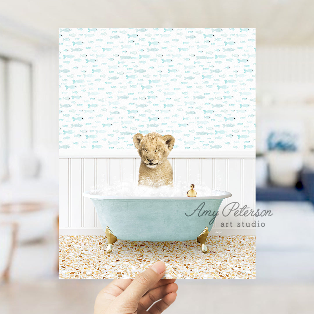 a hand holding a photo of a baby lion in a bathtub