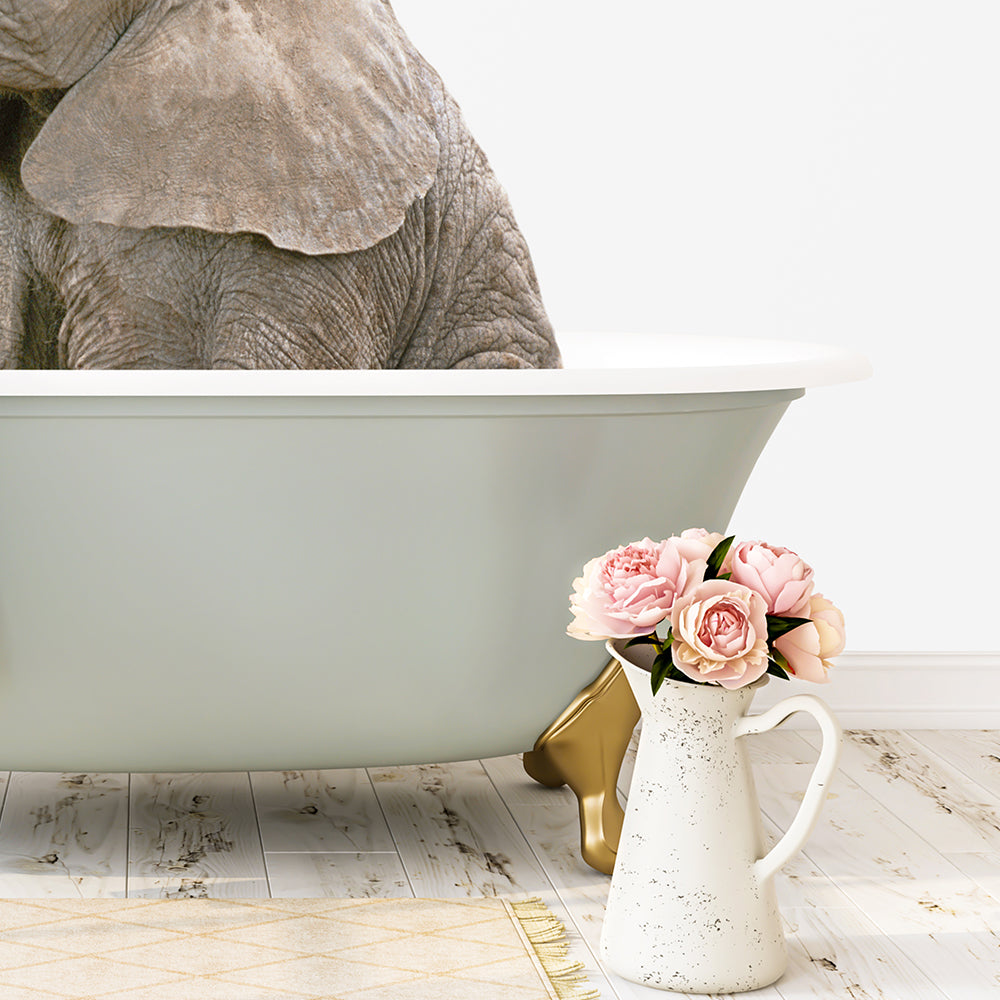 A large elephant is partially submerged in a green bathtub, with a vase of pink flowers placed next to it on a wooden floor.