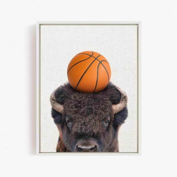 A buffalo with a basketball resting on its head.