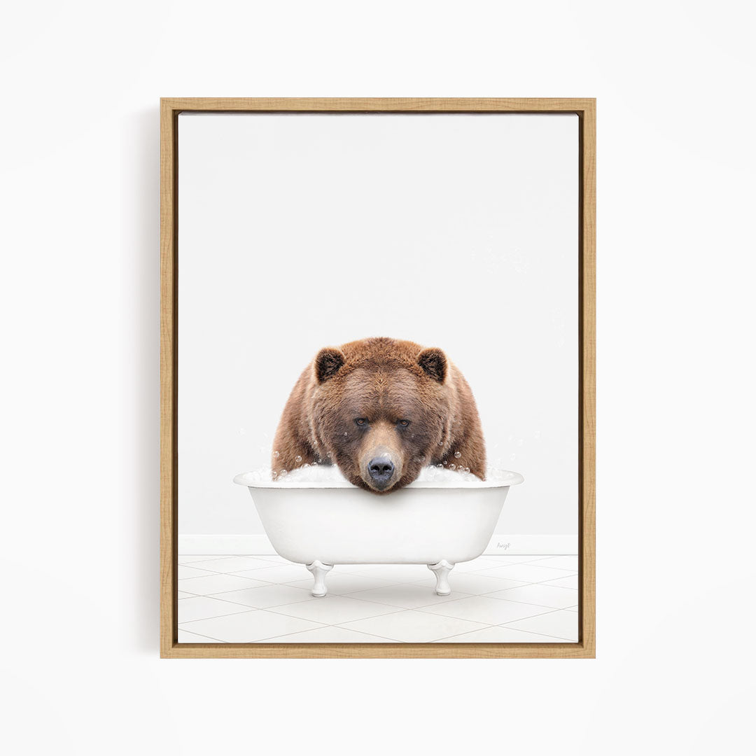 A brown bear is sitting in a white bathtub, appearing to be enjoying a relaxing bath.