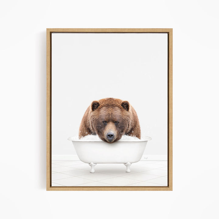 A brown bear is sitting in a white bathtub, appearing to be enjoying a relaxing bath.