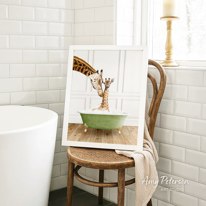 A framed image of two giraffes sitting in a green bathtub, with one giraffe extending its neck over the other.