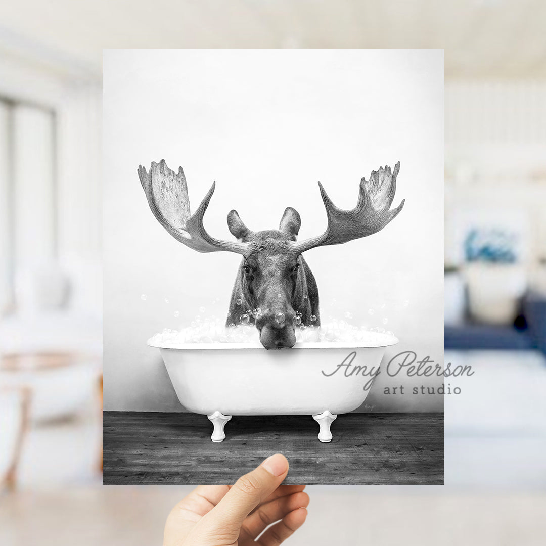 a person holding up a card with a moose in a bathtub