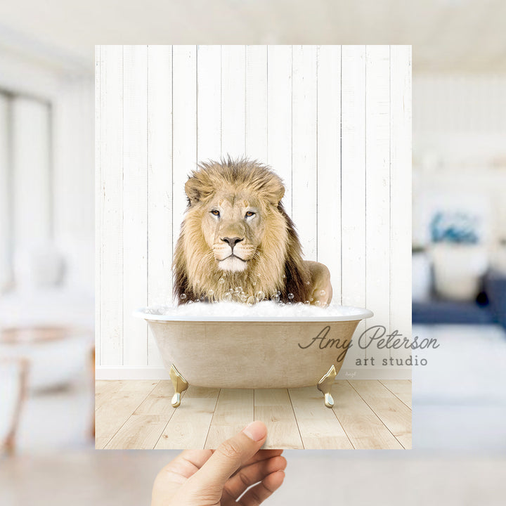 a hand holding a photo of a lion in a bathtub