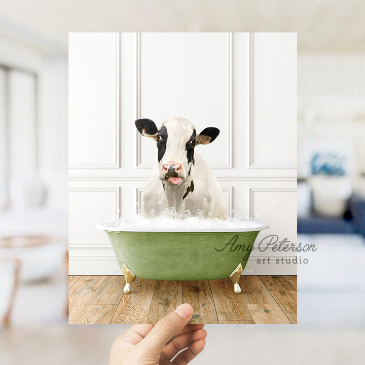 a hand holding a photo of a cow in a bathtub