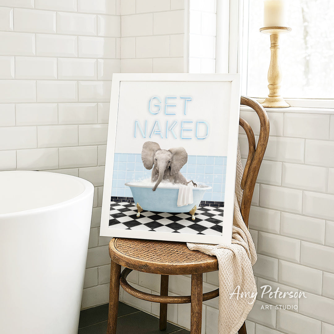A framed image of an elephant sitting in a bathtub, with the text "GET NAKED" displayed on the frame.