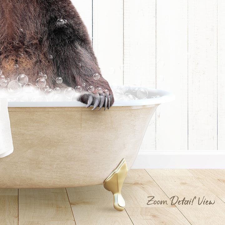 A close-up of a bear's paw in a bathtub filled with bubbles, with a wooden floor and white wall in the background.