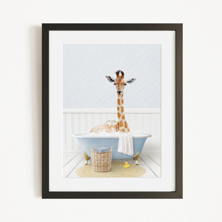 A giraffe standing in a blue bathtub filled with bubbles, surrounded by a yellow rubber duck and a basket.