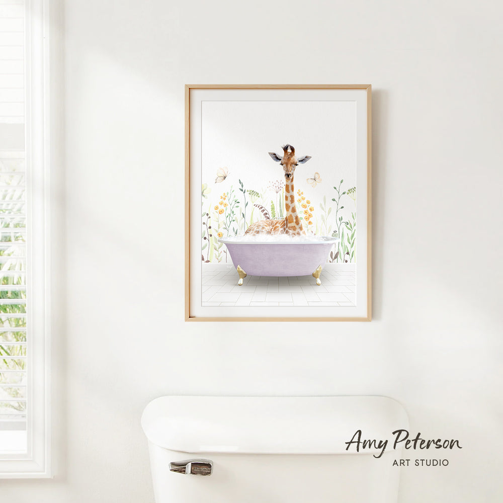 A framed illustration of a giraffe sitting in a bathtub, surrounded by flowers and butterflies, is hanging on a white wall.