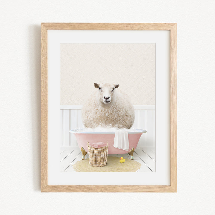 A fluffy white sheep sits in a pink bathtub, surrounded by a yellow rubber duck and a wicker basket.