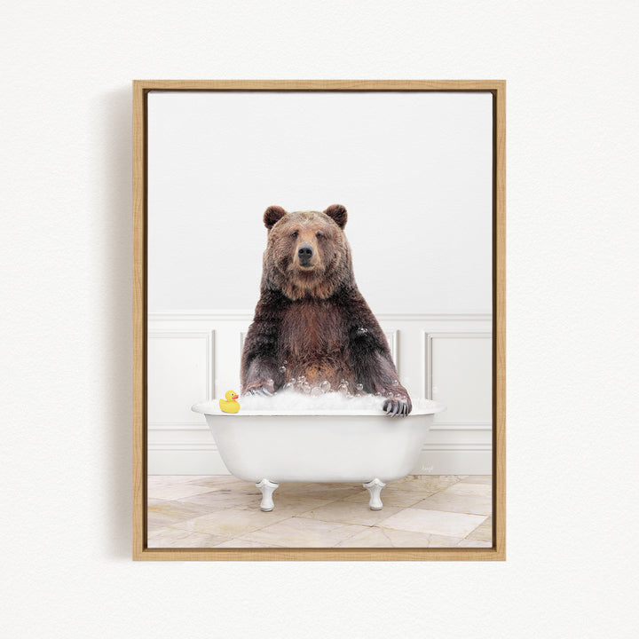 A brown bear sitting in a white bathtub, with a yellow rubber duck floating in the water.