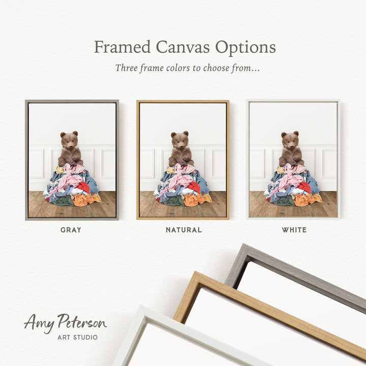 three framed canvas options, each featuring a teddy bear sitting on a pile of clothes. The options include a gray frame, a natural frame, and a white frame.