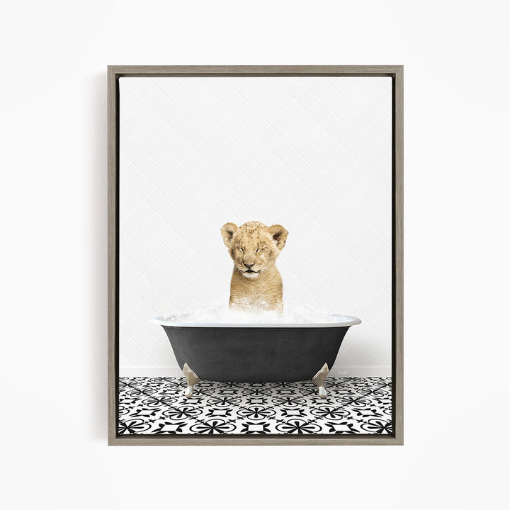A young lion cub sitting in a bathtub filled with water, looking up at the camera.