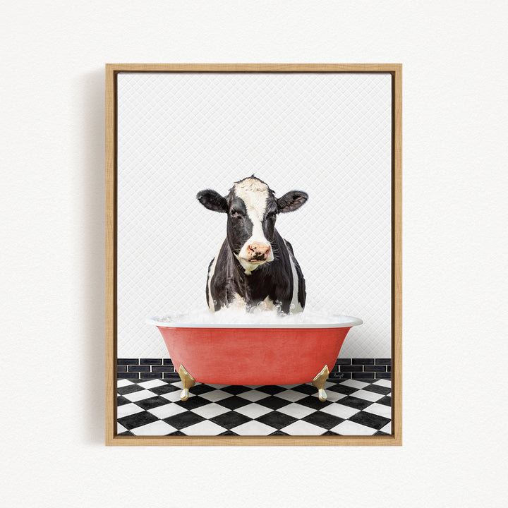 A black and white cow is standing in a red bathtub filled with water, creating a whimsical and humorous scene.