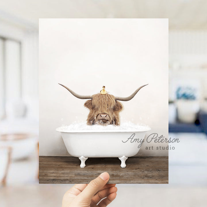 a hand holding a photo of a bull in a bathtub