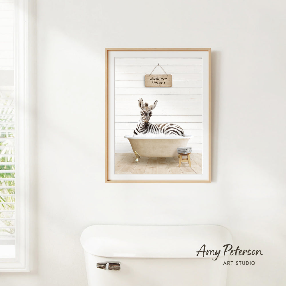 A framed print of a zebra sitting in a bathtub, with a sign above it that says "Wash Your Stomach".