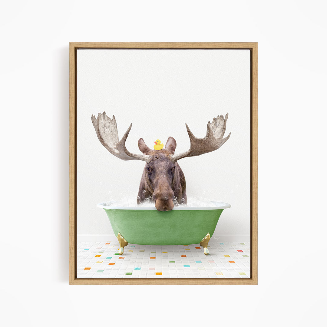 A moose with large antlers is sitting in a green bathtub, with a rubber duck floating on its head.
