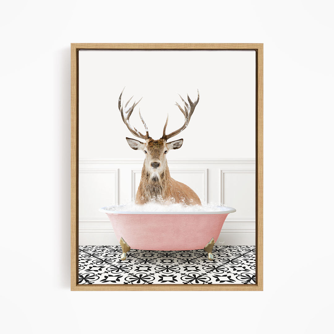 A deer with large antlers is sitting in a pink bathtub filled with bubbles, creating a whimsical and unexpected scene.