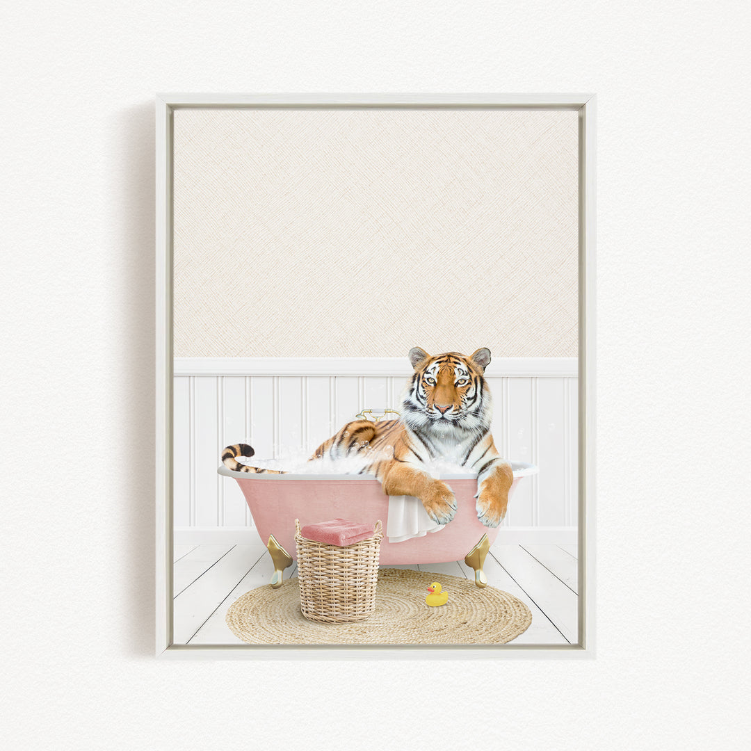 A tiger is sitting in a pink bathtub, surrounded by a basket, a rubber duck, and a white wall.