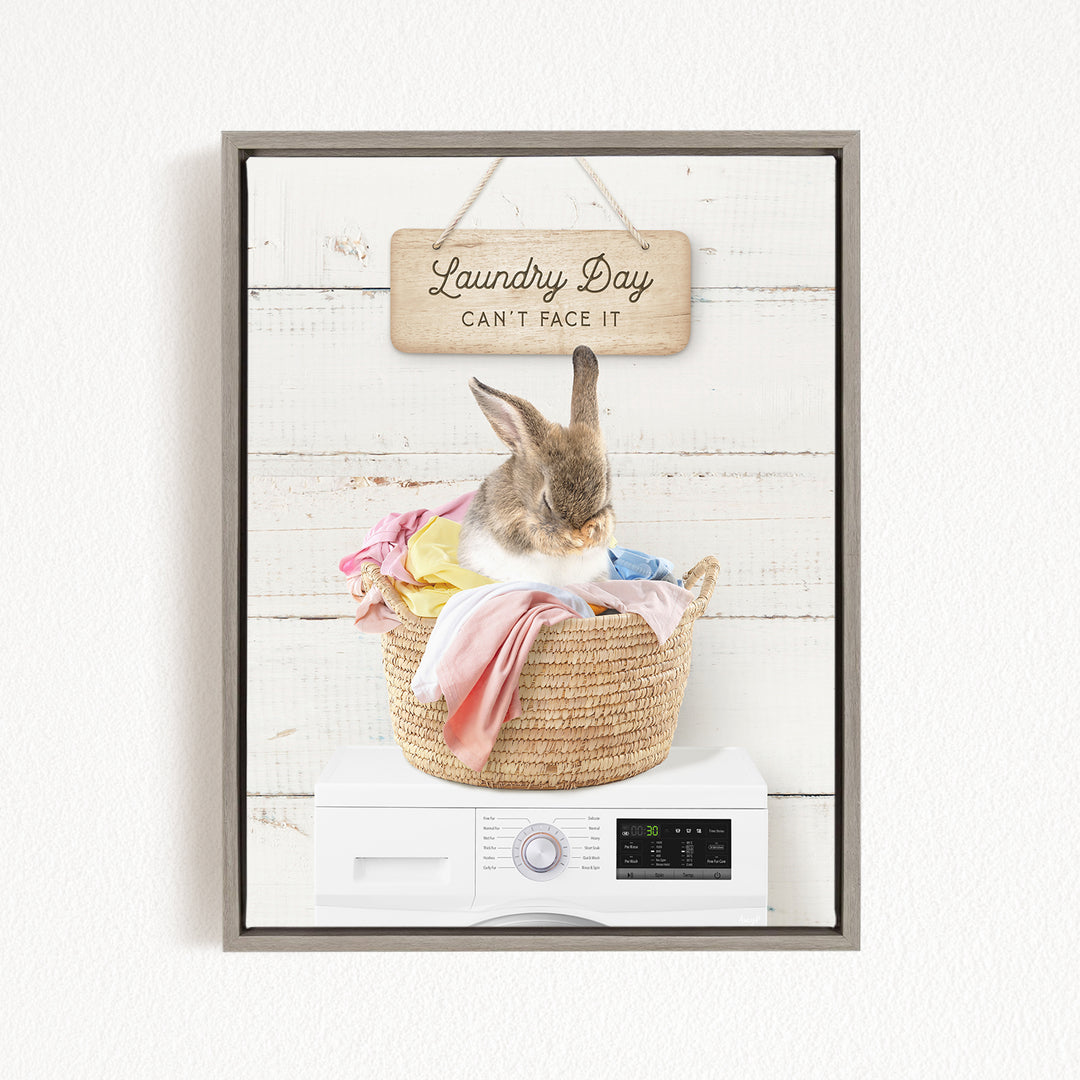 A cute rabbit sitting in a woven laundry basket, with a sign above that says "Laundry Day Can't Face It".