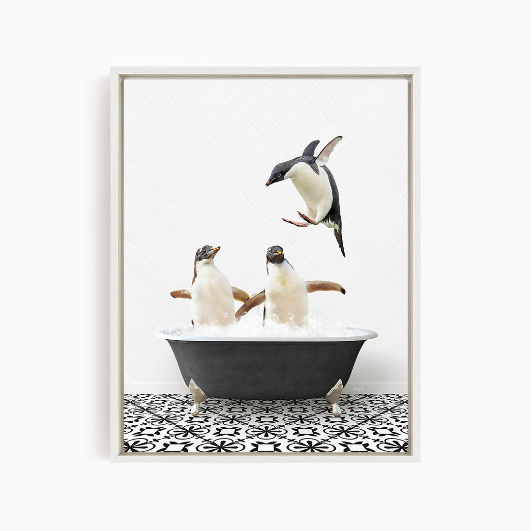 A framed image depicting two penguins standing in a bathtub filled with water, with one penguin jumping out of the tub.