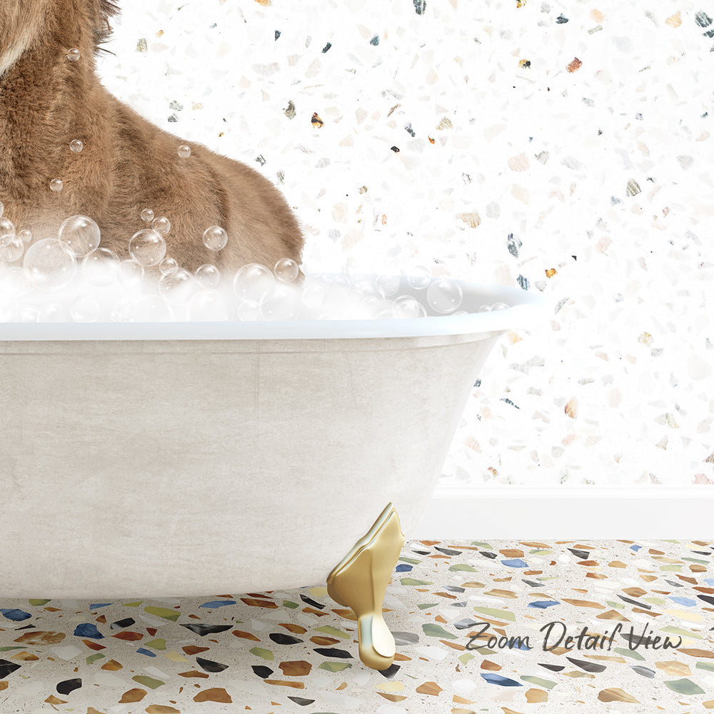 A dog is sitting in a bathtub filled with bubbles, with a mosaic floor in the background.