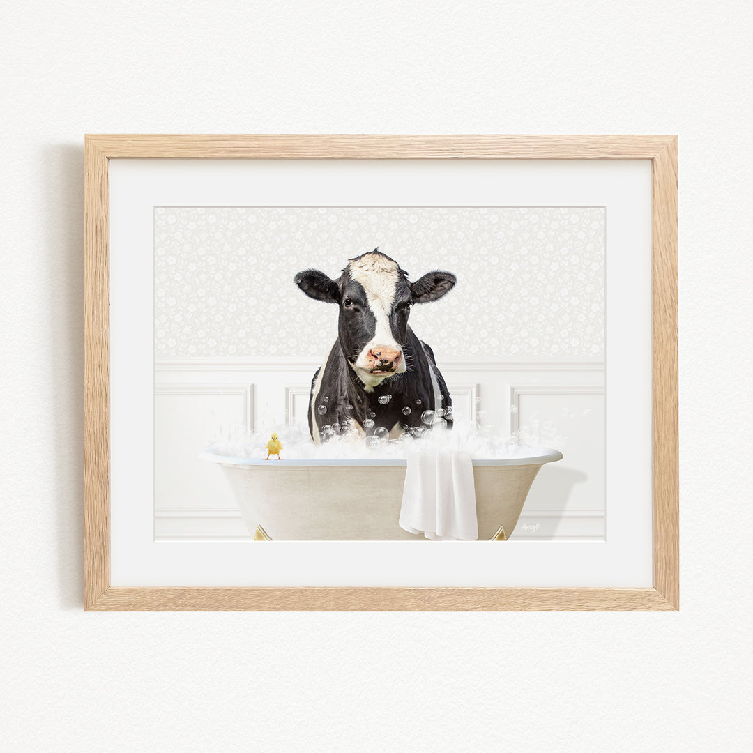A black and white cow is sitting in a bathtub filled with bubbles, appearing to enjoy a relaxing bath.