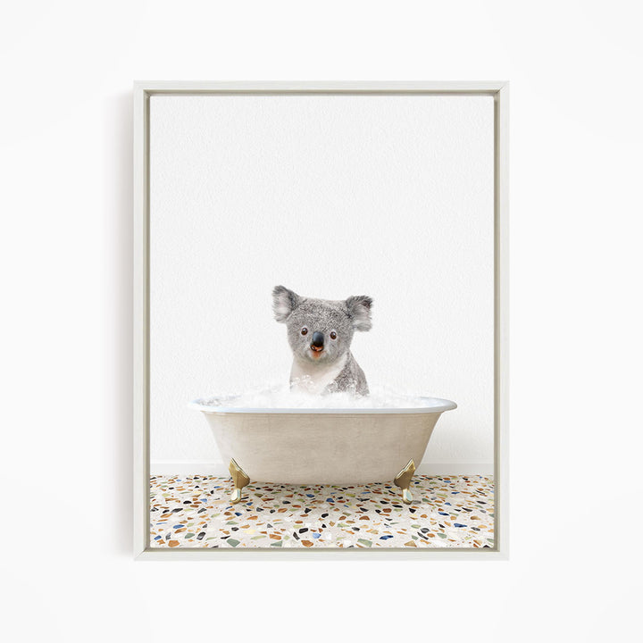 A koala bear sitting in a bathtub filled with water, looking directly at the camera.