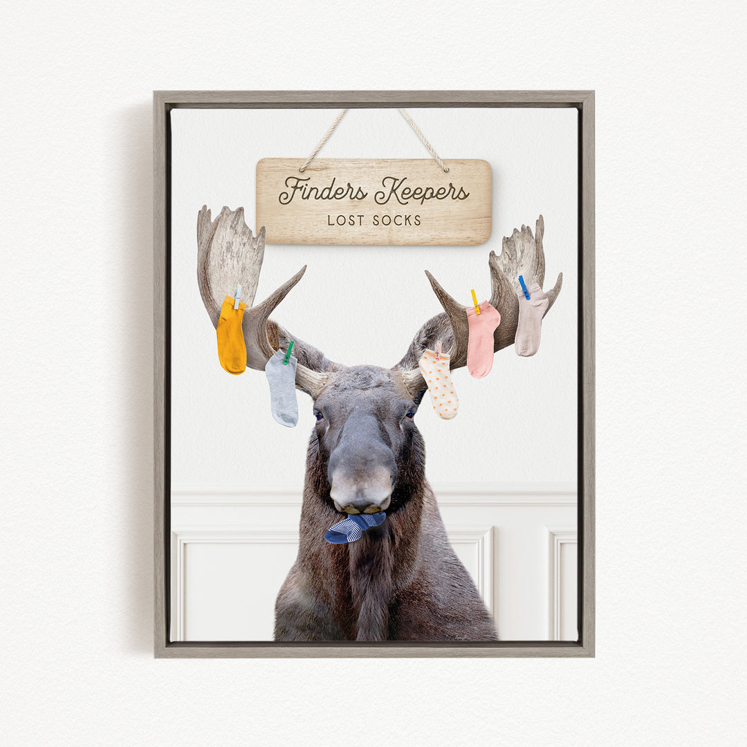 A framed image of a moose with a sign above it that says "Finders Keepers Lost Socks".