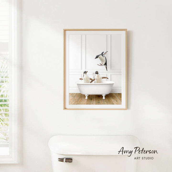 A framed image of two penguins sitting in a bathtub, with one penguin standing on the edge of the tub.