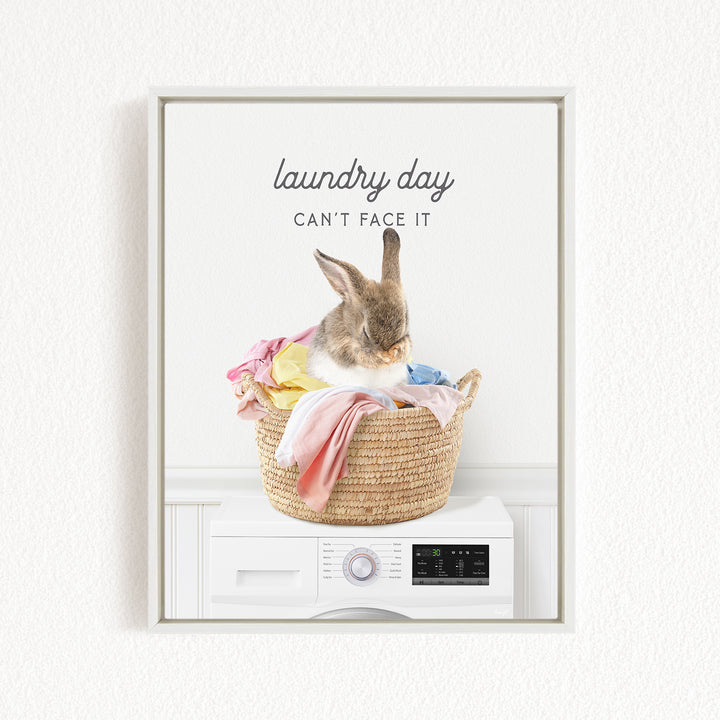 A rabbit sitting in a basket filled with laundry, with the text "laundry day can't face it" above the basket.