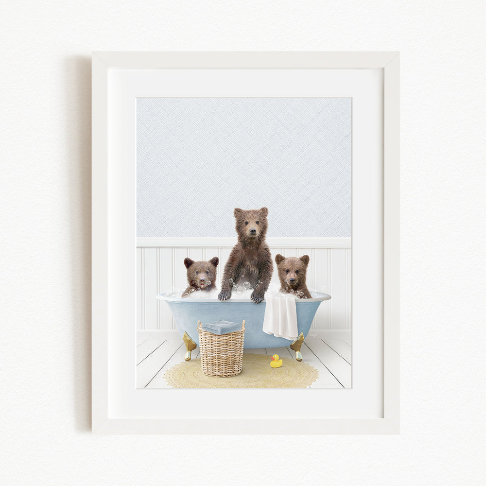 A framed image depicting three bears sitting in a bathtub, with one bear sitting on the edge of the tub and the other two bears sitting inside the tub.