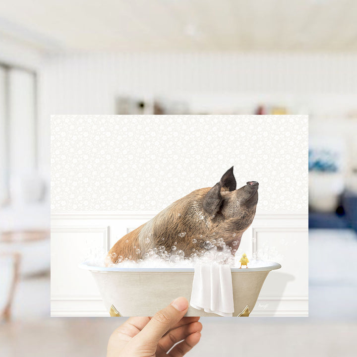 A hand holds up a collage of images depicting a pig bathing in a tub, with a yellow duck nearby.