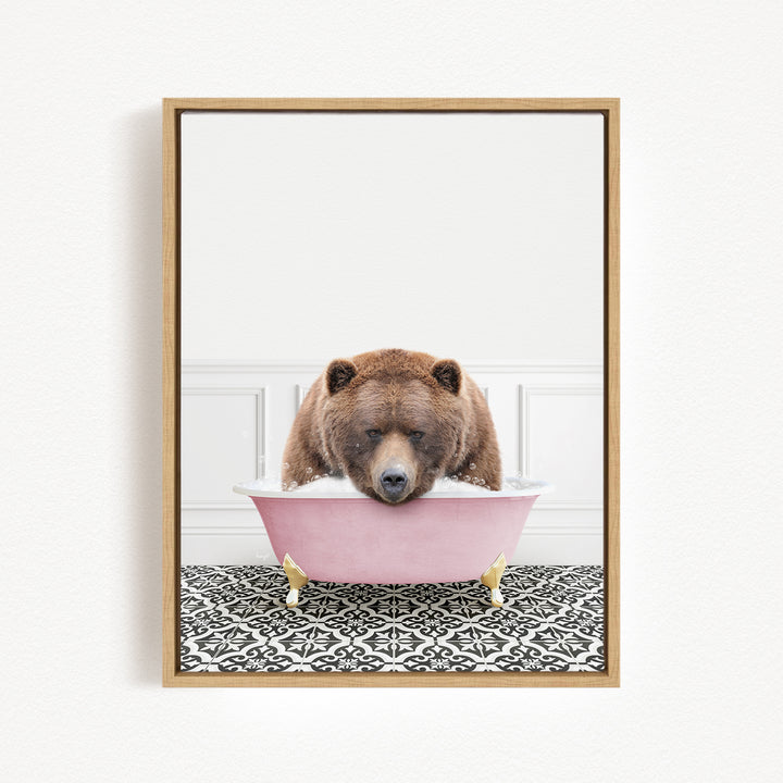 A brown bear is sitting in a pink bathtub, appearing to be enjoying a bath.