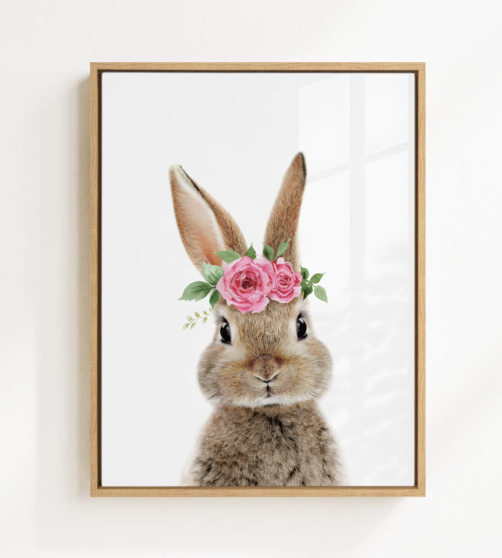 A cute bunny rabbit wearing a floral crown of pink roses and greenery.