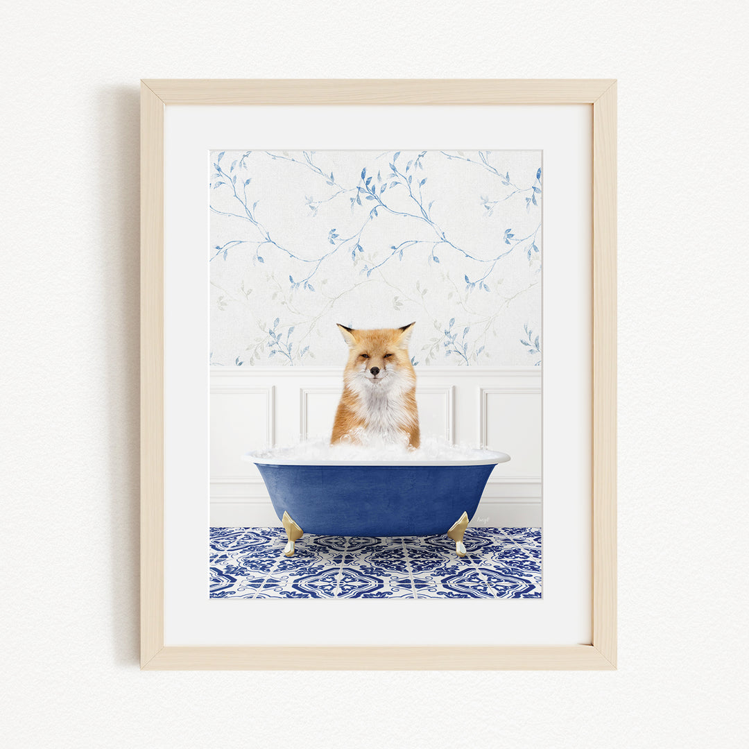 A red fox is sitting in a blue bathtub filled with bubbles, looking directly at the camera.
