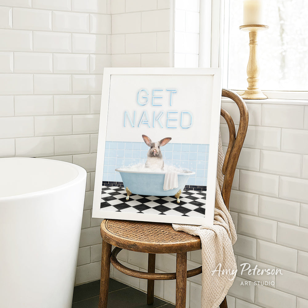 A framed image of a pig sitting in a bathtub, with the text "GET NAKED" displayed on the frame.