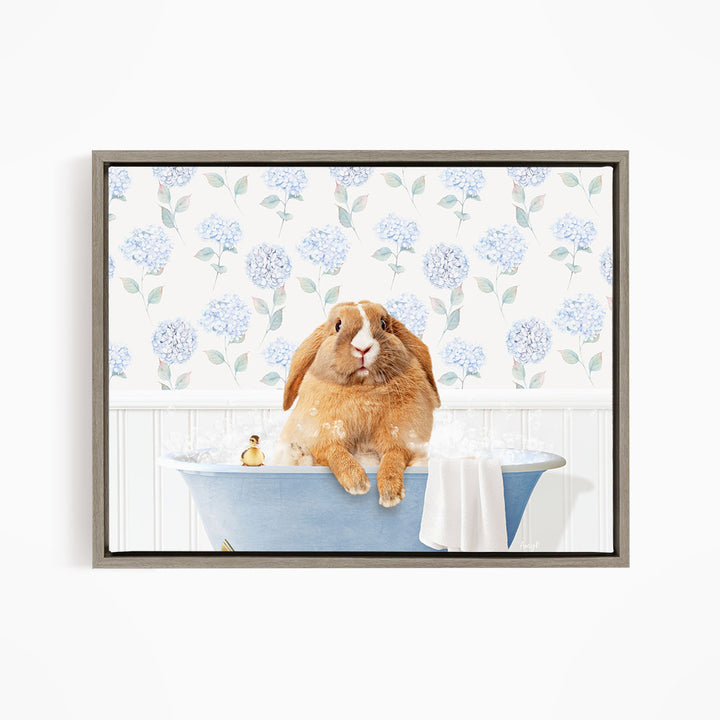 A brown rabbit sitting in a blue bathtub filled with water, surrounded by a floral patterned wall.