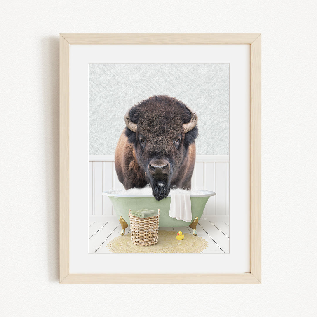 A buffalo standing in a green bathtub, with a basket of rubber ducks nearby.