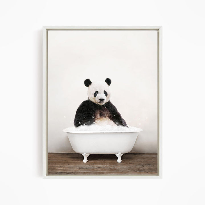 A panda bear sitting in a white bathtub filled with bubbles, looking directly at the camera.
