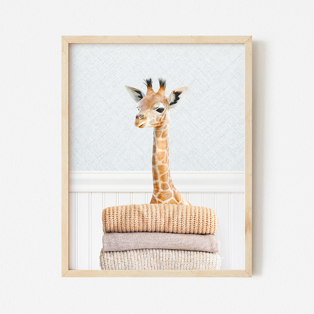 a giraffe standing on top of a pile of towels