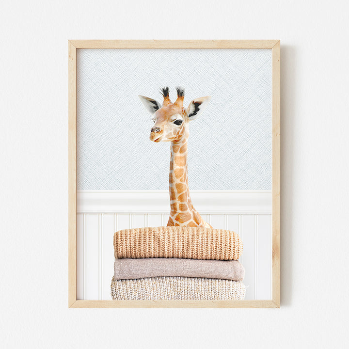 a giraffe standing on top of a pile of towels