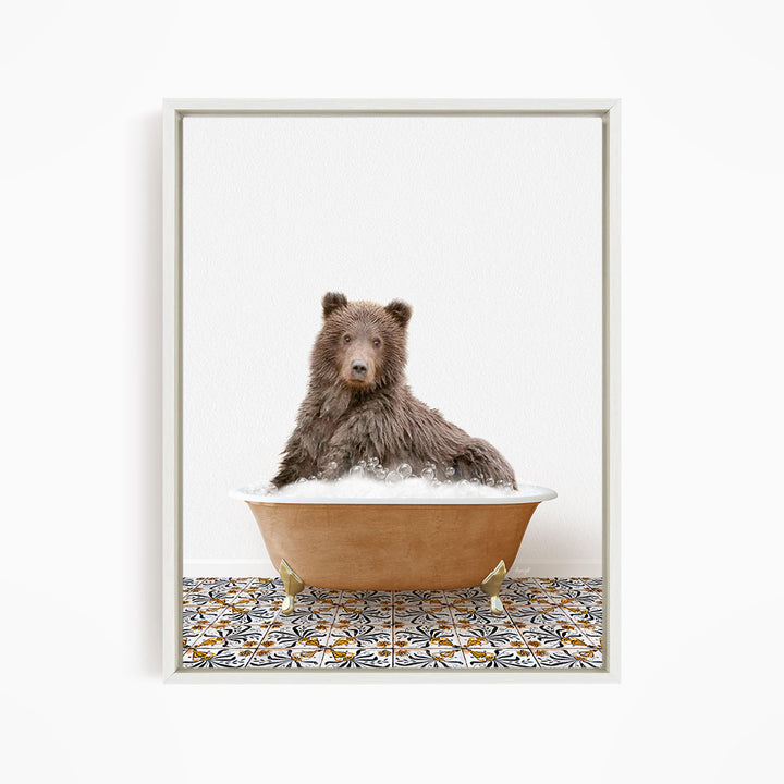 A brown bear sitting in a bathtub filled with bubbles, looking directly at the camera.