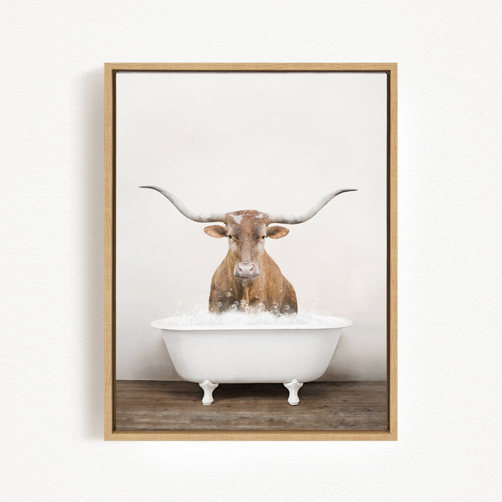 A brown cow with large horns is sitting in a white bathtub filled with water, creating a whimsical and humorous scene.